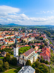 Aerial view of St. Stephen's Cathedral in Litomerice, showcasing the vibrant town with historical buildings, green parks, and surrounding hills.