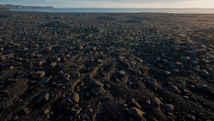 Dark volcanic sand surface with shimmering texture, ideal for UI backdrop or editorial headers