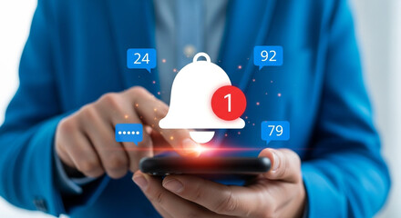 A person in a blue suit jacket holds a smartphone with a notification bell icon on the screen