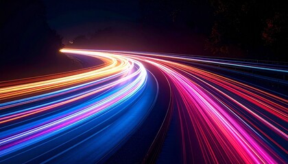 Long-exposure night photo of curved highway with vibrant multicolored light trails against dark background.