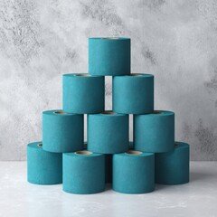 Stacked turquoise paper rolls against a concrete background