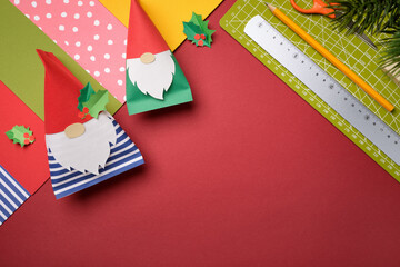 DIY background with handemade paper gnomes and craft supplies. Flat lay workshop concept. Space for your text.