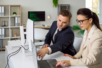 Business teamwork meeting shows strategy analytics discussion. In an office colleagues work at a computer monitor, reviewing data to align goals and plan. Clear business team decision making.