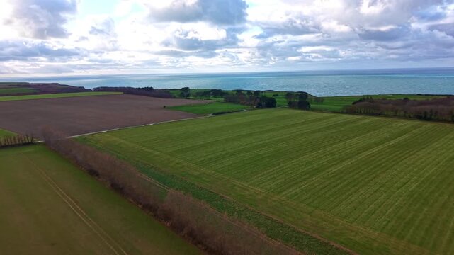 Aerial Perspective of the Agricultural Plateaus Overlooking Etretat, where the verdant fields of Normandy meet the rugged watersand wild maritime border of La Manche, English Channel, France.
