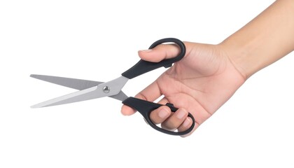 A human hand grasps a pair of open metal blades with black handles, isolated on a white background, ready for use