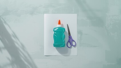 A glue bottle, scissors, and paper arranged for craft projects, highlighting workspace organization