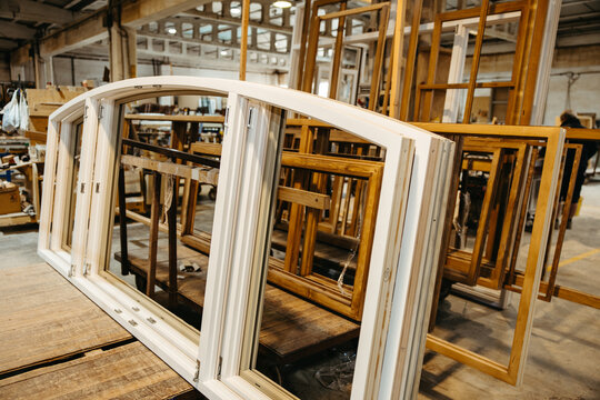 Oval wooden door and window frames in carpentry workshop