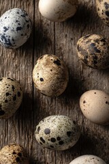 Obraz premium A collection of speckled eggs arranged on a rustic wooden surface. Concept Earthy textures, Speckled eggs, Rustic wood, Natural palette, Organic still life