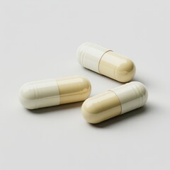Three cream and white pharmaceutical capsules arranged on a light gray surface pill