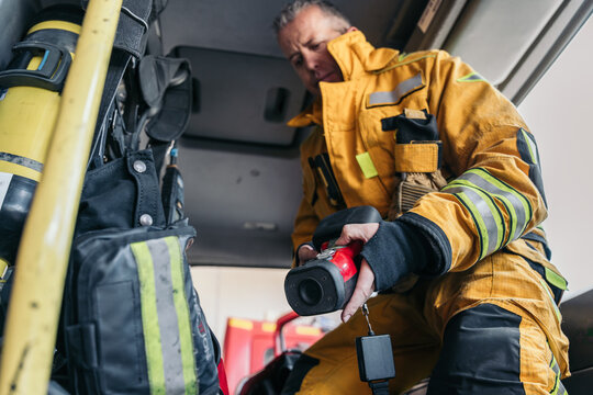 Firefighter preparing thermal imaging camera in firetruck