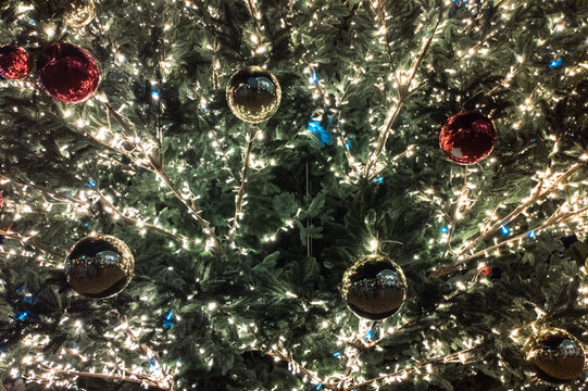 Christmas balls on blue artificial spruce close-up
