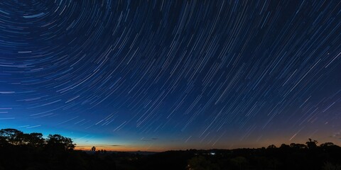 Star trails in the colorful night sky above a suburban area in Sydney, NSW, Australia, for light pollution awareness