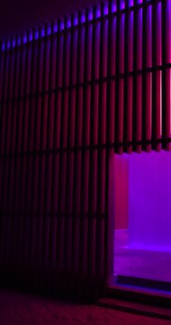 A multicolored light structure with wooden railings at night, concept artsy architecture shot