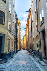 Secluded old town alley with vibrant facades and stone pavement in Stockholm