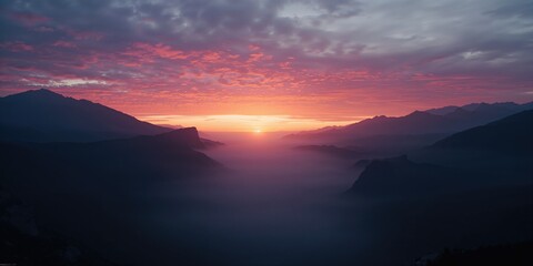 Fototapeta premium Dusk illuminates mountainous terrain with fog settling in the valley, highlighting erosion risk