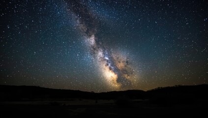 Fototapeta premium Night sky featuring the Milky Way arching above a seaside area, highlighting celestial visibility, World Astronomy Day