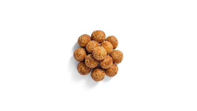Roasted thala balls displayed on plain white surface highlighting preparation technique