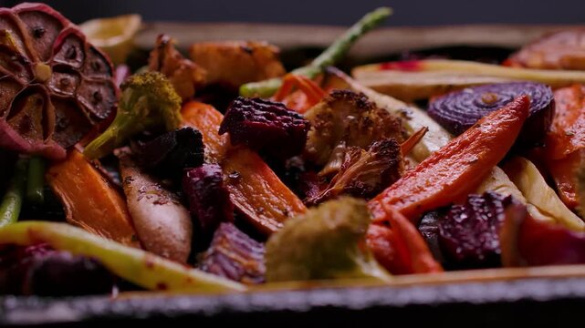 Panning close up over appetizing roasted vegetables. Beets, carrots, parsnips, and broccoli prepared for a healthy family Sunday roast dinner