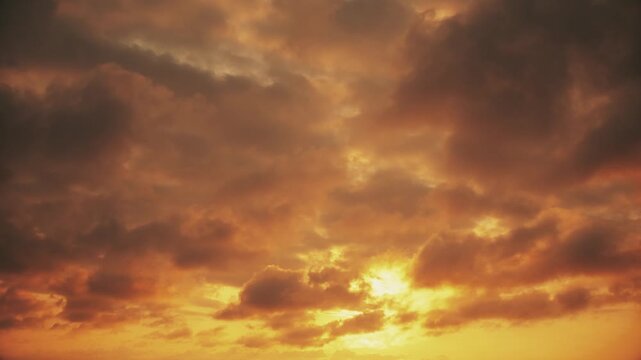 A panorama of orange sky and clouds at dawn. The sun breaks through the clouds early in the morning at sunrise. A peaceful natural backdrop.