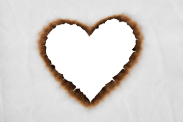 heart shaped transparent burned hole in white paper with dark charred edges creating a romantic and dramatic background for design and love themed concepts