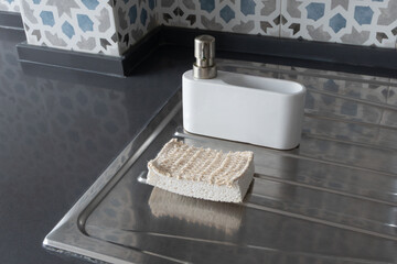 Eco-friendly kitchen cleaning setup with soap dispenser and natural cleaning dish sponge. Zero waste lifestyle