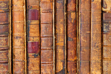 Row of ancient medieval weathered books with leather covers