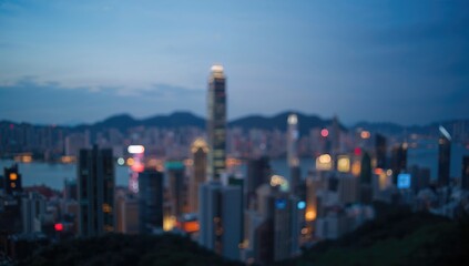 Obraz premium Blurred Hong Kong cityscape with illuminated skyscrapers, suitable for editorial header backgrounds or urban design projects