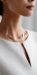 Elegant minimalist gold necklace worn on a female neck with a white modern outfit.