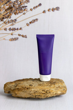Packshot produit de beaut&eacute; - tube de cr&egrave;me violet - mockup tube de cr&egrave;me - style proven&ccedil;ale - lavande, roche et nappe en lin