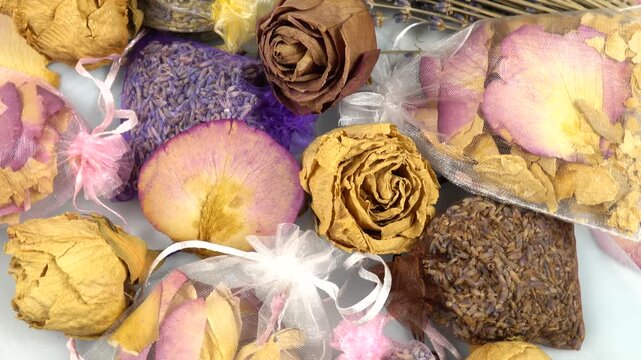 Dried lavender organza sachets filled with petals and buds lie on a table, top view