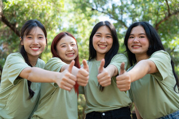 Thumbs Up and Smiles: A group of smiling people giving a thumbs up sign, surrounded by verdant leaves, radiating positive energy and expressing the concept of approval.
