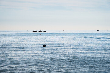 Obraz premium people silhouette on a boat in front of a Adriatic Sea beach during a summer day, Bibione Pineda, Venice, Italy
