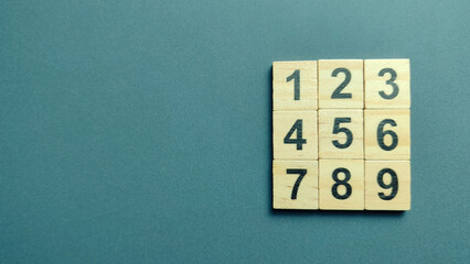 Grid Arrangement of Wooden Tiles with Numbers One Through Nine on Dark Background for Math Concept