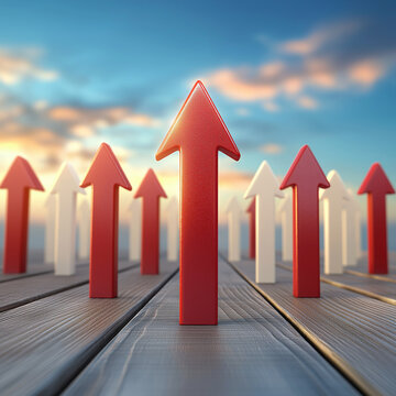 Red arrow leading group of upward arrows on wooden floor at sunrise conveying growth and leadership