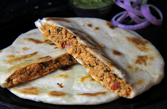 Fluffy dhabba-style chicken kulcha served on a plate. A classic North Indian flatbread stuffed with spiced chicken filling, cooked to golden perfection.
