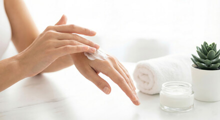 Close up of woman applying white moisturizing cream on her hand. Skincare and beauty spa concept.