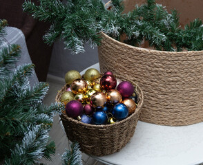 Disassembled artificial Christmas tree with ornaments in wicker basket