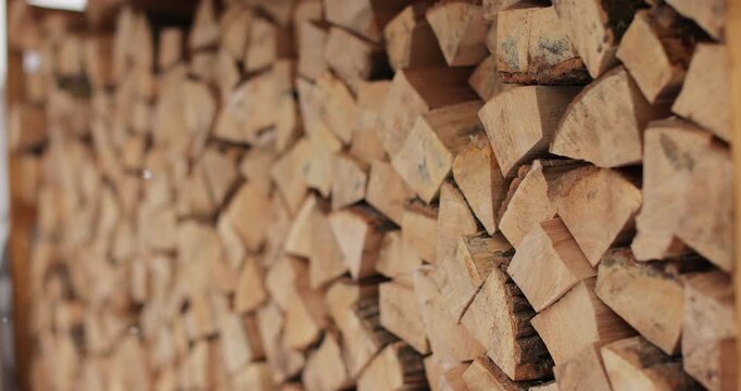 Close-up of a large pile of chopped dry wood for a fireplace or stove. Logs for the fire. Harvesting dry firewood for the winter.