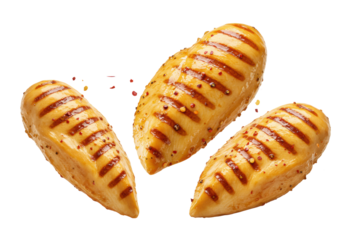 Three succulent, golden-brown grilled chicken breasts with char marks, seasoned with red chili flakes and black pepper, scattering mid-air against a transparent background, concept for gourmet food