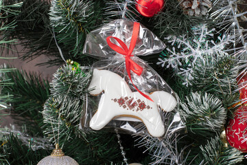 Gingerbread horse hangs on Christmas tree. Closeup