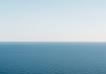 Fototapeta premium A vast, featureless horizon line where the deep blue ocean water meets the pale, open sky. Complete emptiness and infinite possibility, deep, flat, surface