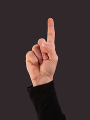 Man hand doing pointing up gesture on a black background