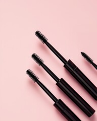 Three Different Mascara Applicators and Brushes on a Soft Pink Background for Beauty Styling