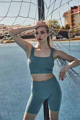 Sportive young woman enjoys exercising outdoors under the bright spring sun