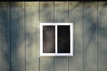 white sliding window on green wall 