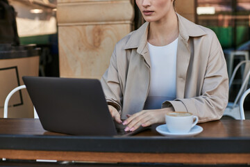 Fototapeta premium Blonde woman enjoying coffee and work at a charming outdoor cafe terrace