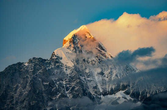 drone image of golden peak of Mount Siguniang in the setting sun