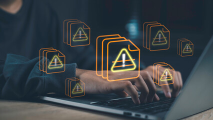 Hands on laptop with glowing warning triangle icons on file symbols, representing data theft, cybersecurity risks, file system vulnerability, and internet security threats in a digital network.