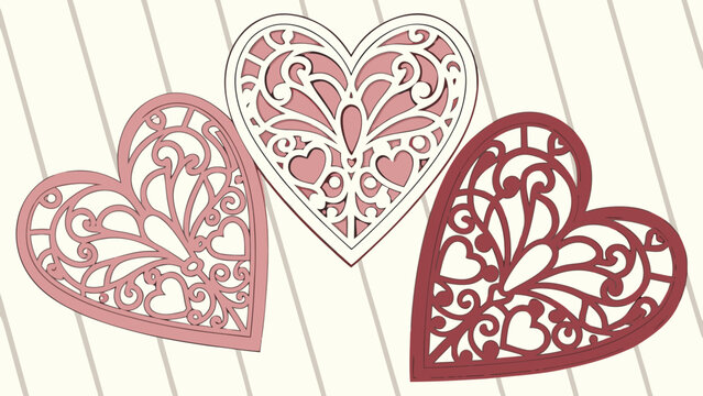 Three intricately designed decorative hearts in shades of pink and red showcasing delicate filigree patterns and small heart cutouts against a light striped background
