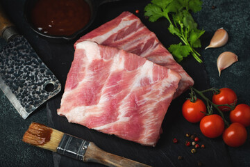 Raw meat. Raw pork ribs from the back with meat on a black background. background image